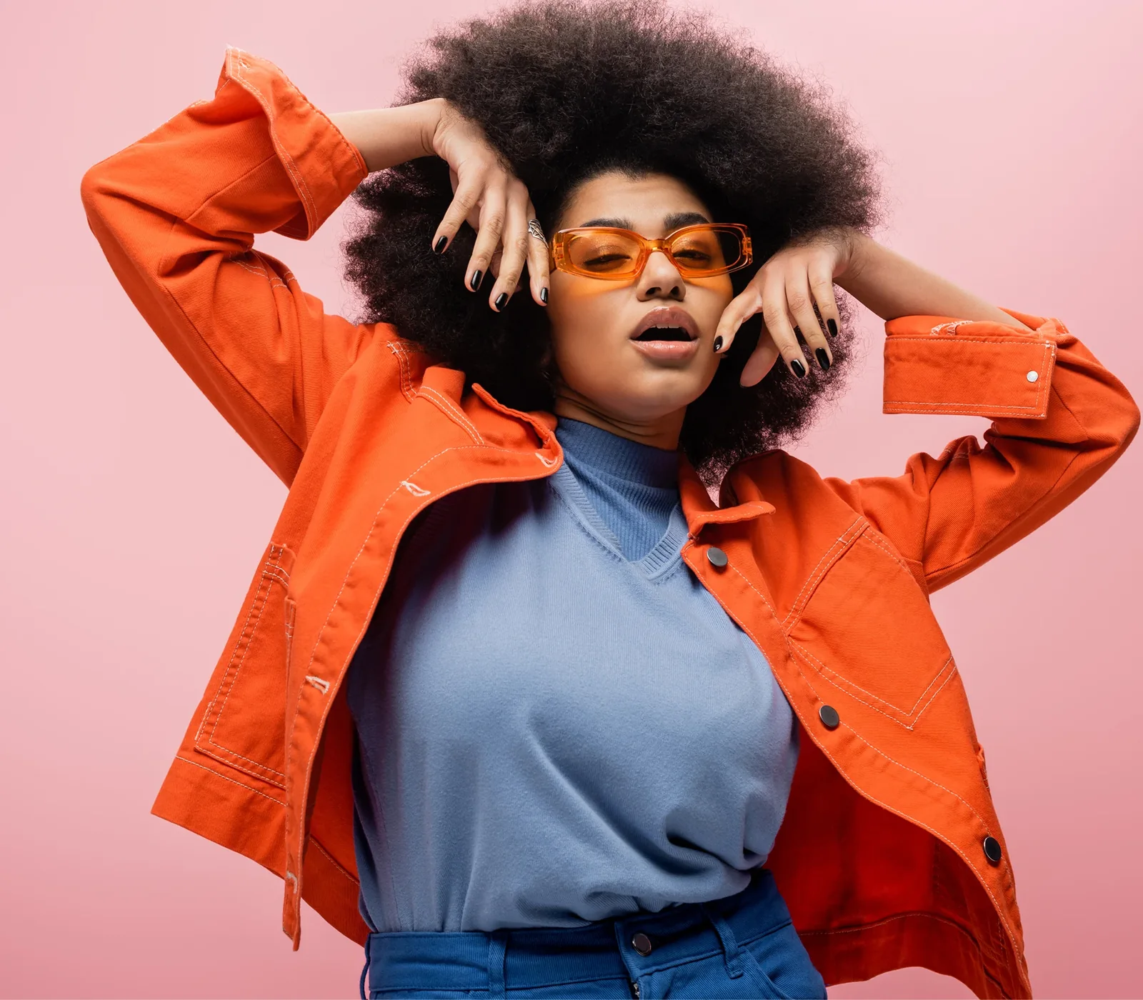 Model in an orange jacket wearing orange sunglasses